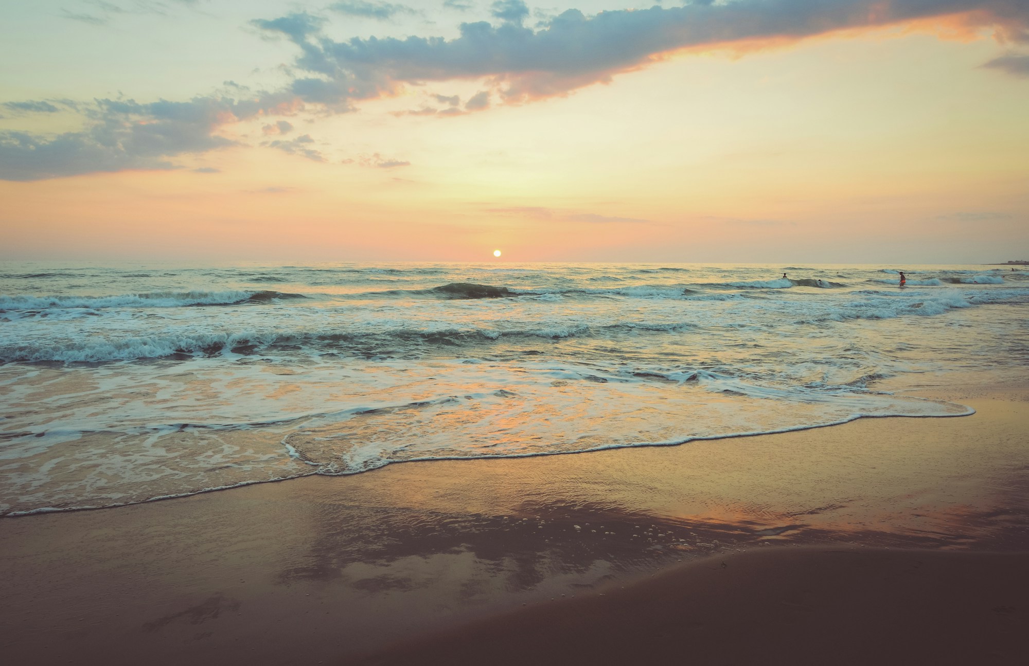 Sanfte Wellen an einem weiten Strand im Abendlicht